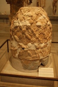 The Delphic Omphalos, c. 330 BCE, literally meaning ‘navel’, it is the renowned Oracle as the center of the earth. A carved stone in the form of a wicker bee-skep. Delphi Archaeological Museum, Greece. 